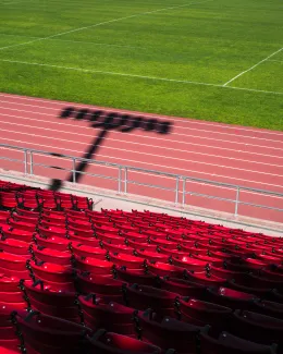 View into sport stadium with the seats, the track and some grass