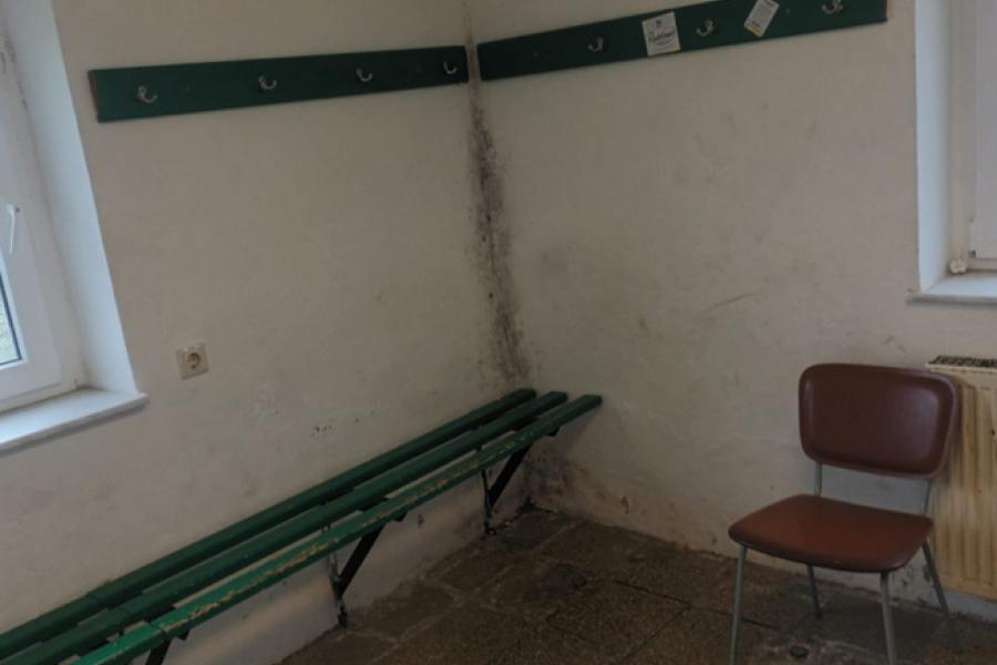 schimmelige Umkleidekabine, grüne Bank weiße Wand